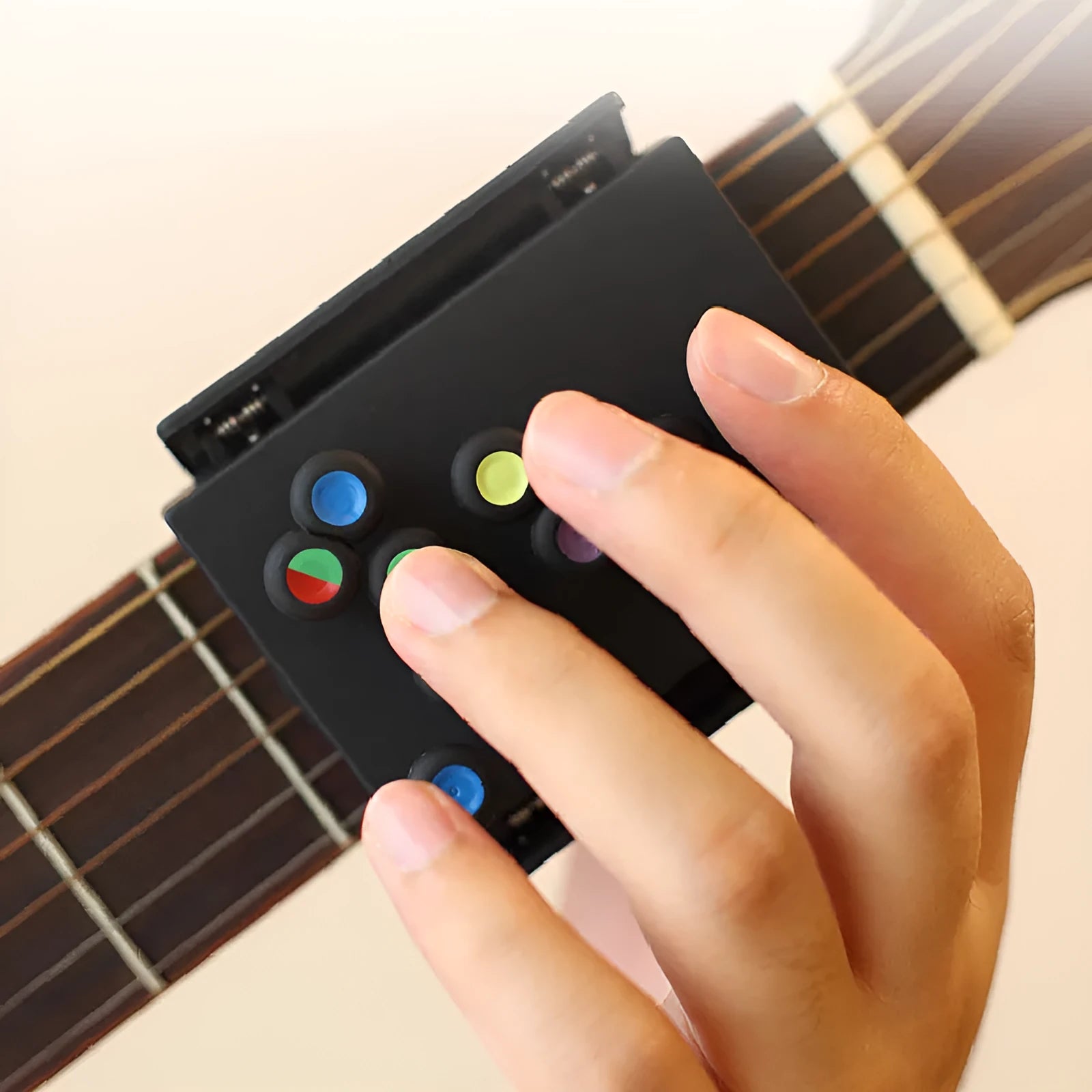 Black guitar finger trainer attached to a folk guitar fretboard