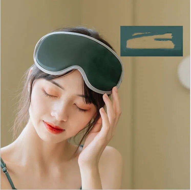 Green portable steam sleep massage goggles with suede shell on a grey background.