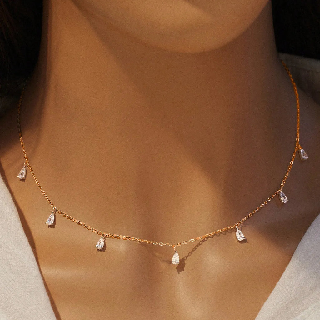 A drop-shaped sterling silver zircon pendant necklace on an O-chain, shown in silver, rose gold, and golden yellow finishes.