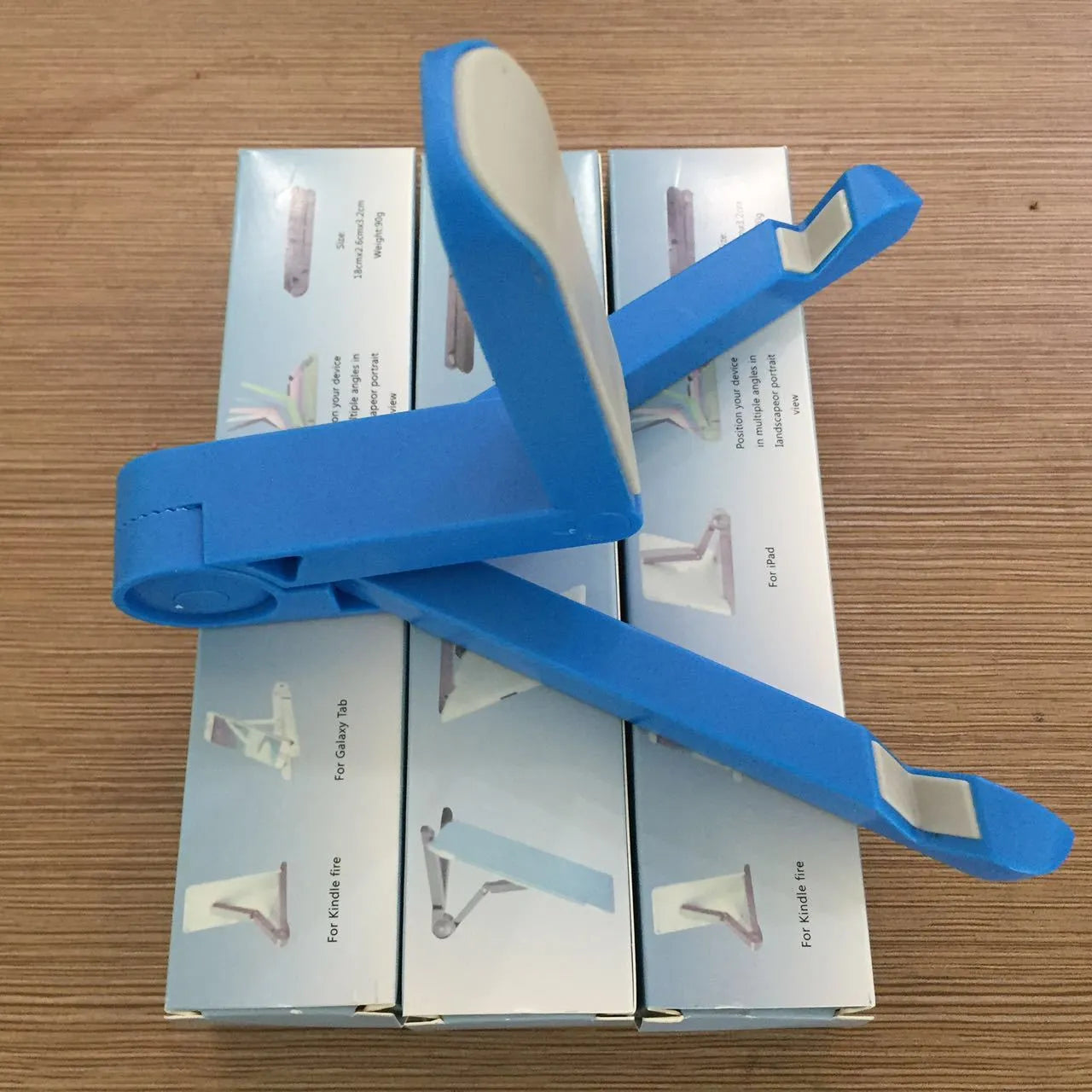 Black foldable tablet holder showing adjustable angles and rubber surface for device protection
