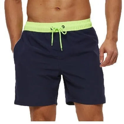 Men's blue training shorts with stitching waist detail, drawstring, and a zipped pocket on the leg.