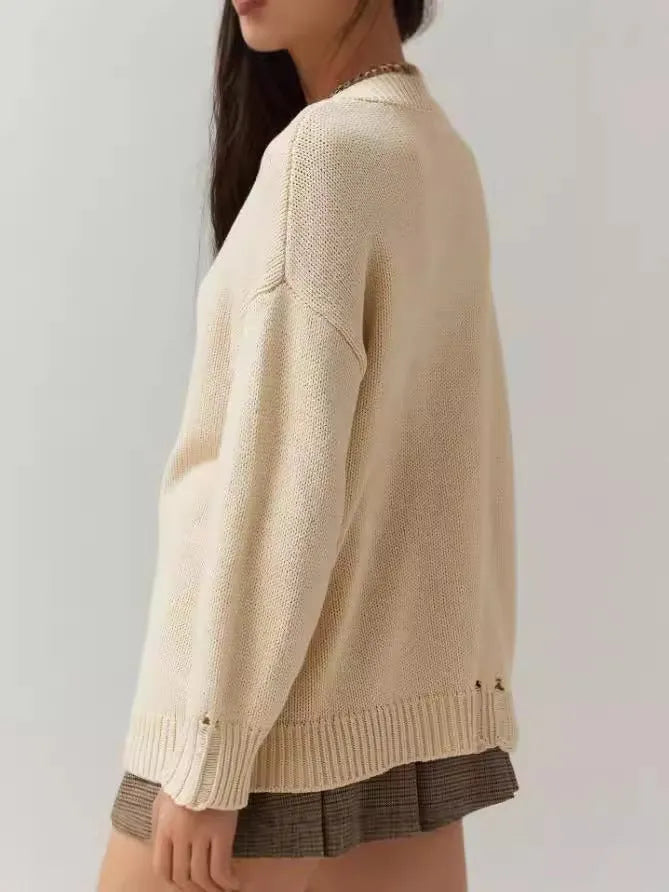 Women's loose-fitting milky white acrylic sweater with jacquard pattern and round neck.