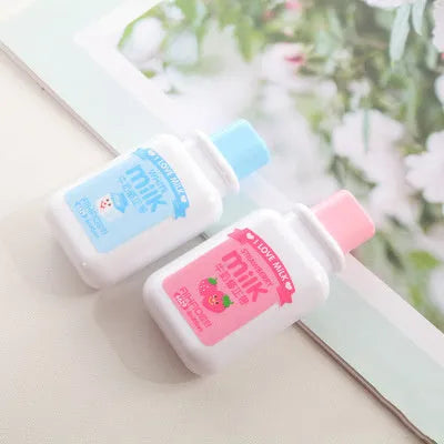 A cute, patterned bottle-shaped correction tape dispenser with a curved design, shown on a paper surface.