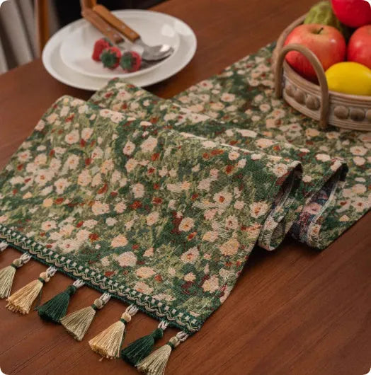 Country European retro style table flag with handwoven tassels in blue ginkgo leaf pattern lying on a wooden table.