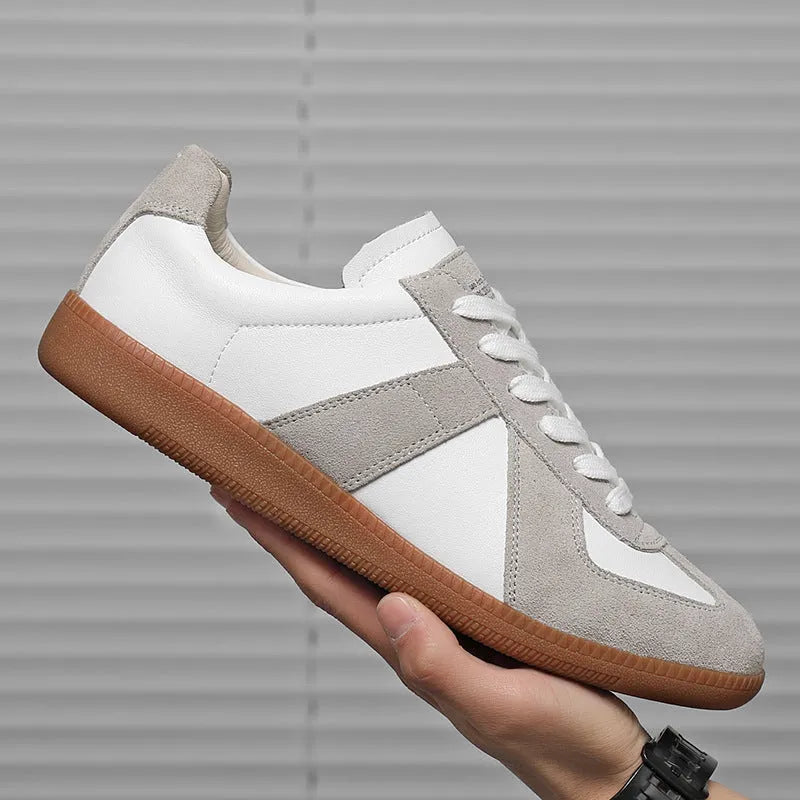 White Japanese-style retro low-top sneakers with round toe and flat rubber sole on a plain background.