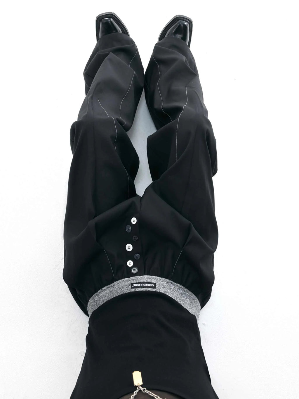 A pair of high-waisted straight-leg casual trousers in grey, showing the button-fly detail.