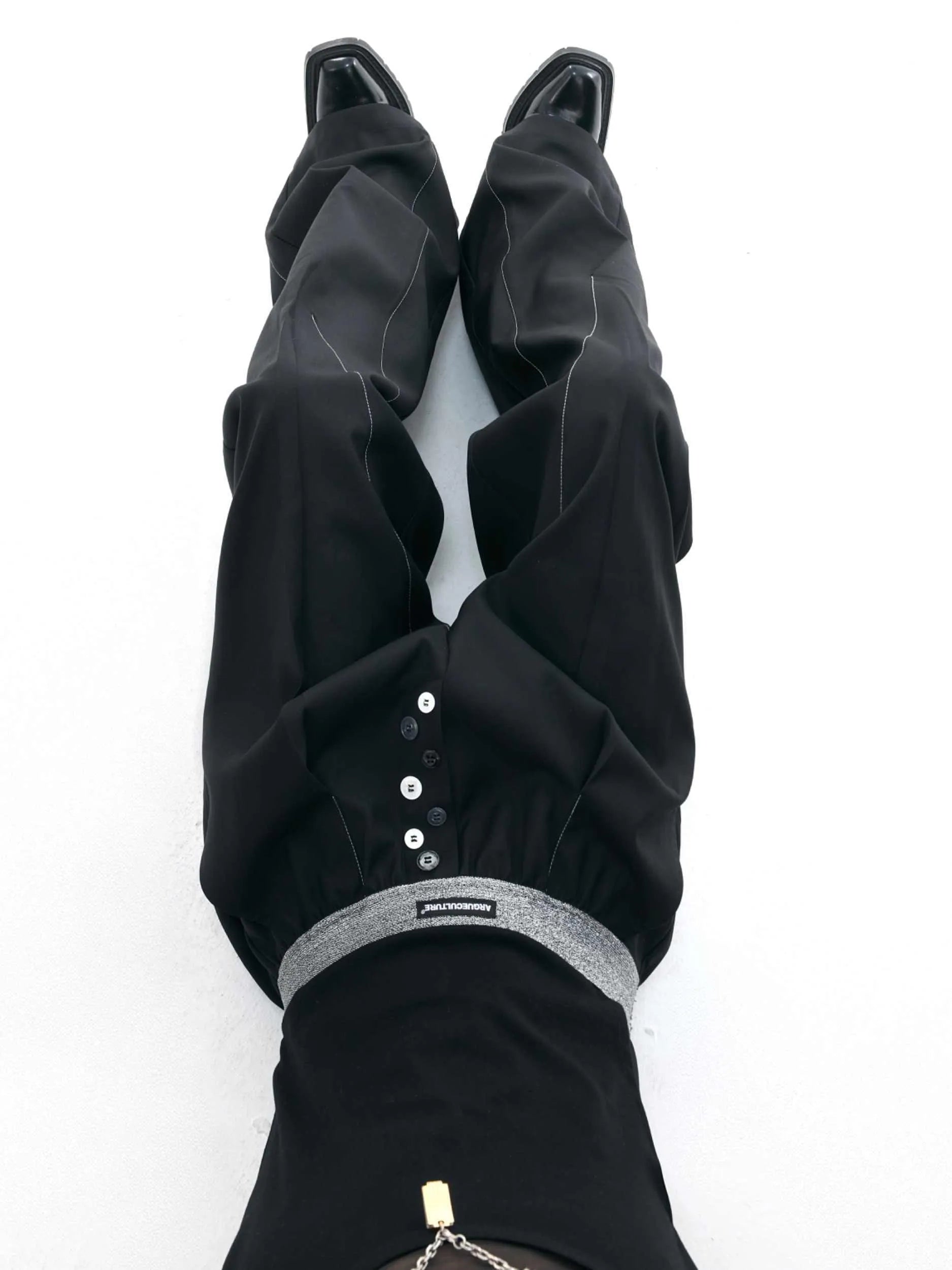 A pair of high-waisted straight-leg casual trousers in grey, showing the button-fly detail.