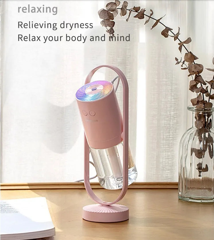 Pink Magic Shadow USB air humidifier with projection night lights on a wooden table.