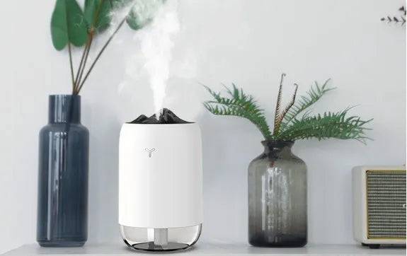 Mini cylindrical USB humidifier with night light in turquoise green, showing water tank and mist outlet