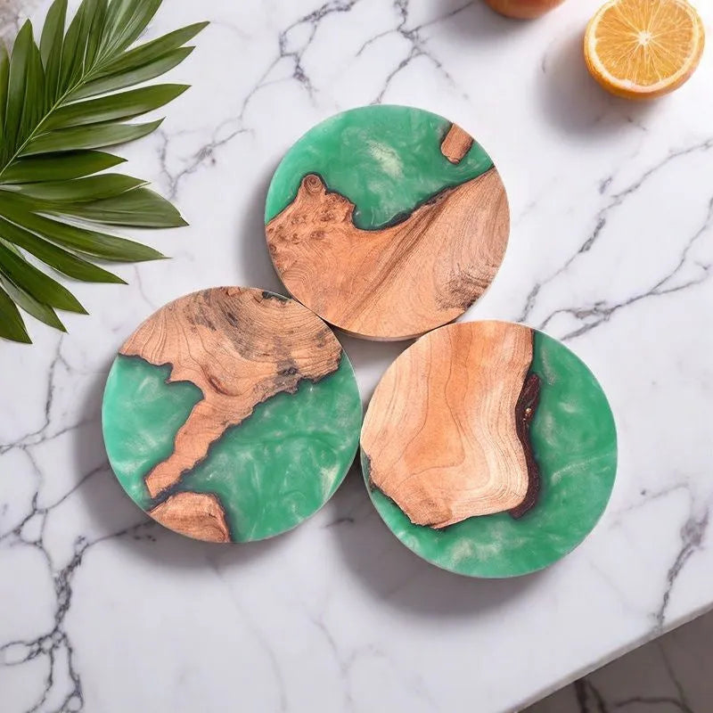 Set of solid colour resin coasters in black and green, showing round and square shapes on a wooden table.