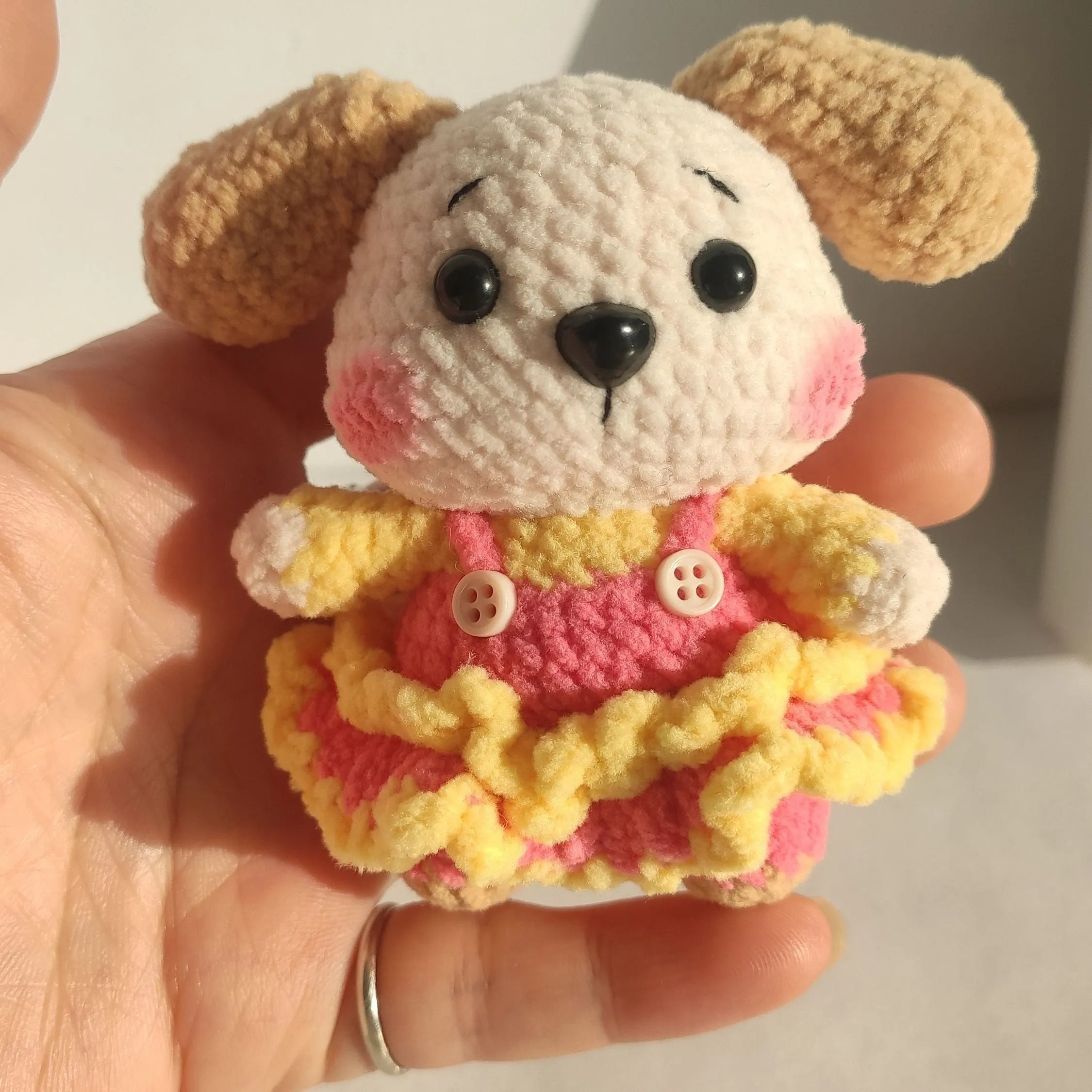 Handmade woollen zodiac dog pendant charm on a keychain, shown in pinafore dress style.