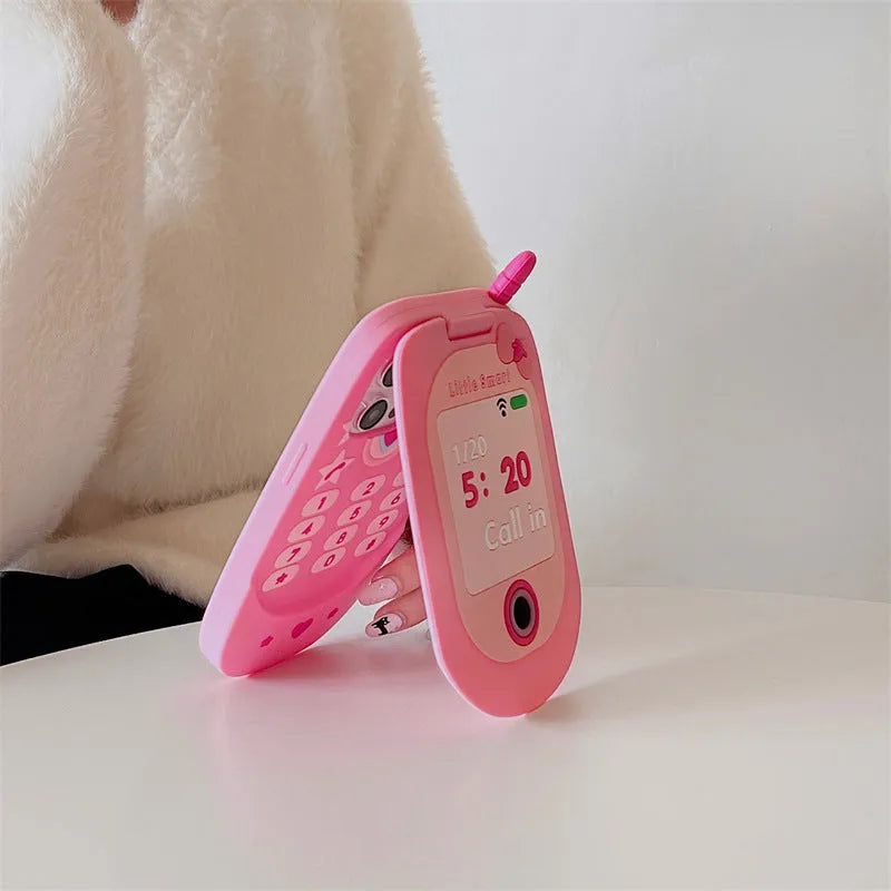 Pink silicone flip phone case for iPhone with a built-in compact mirror on the front.