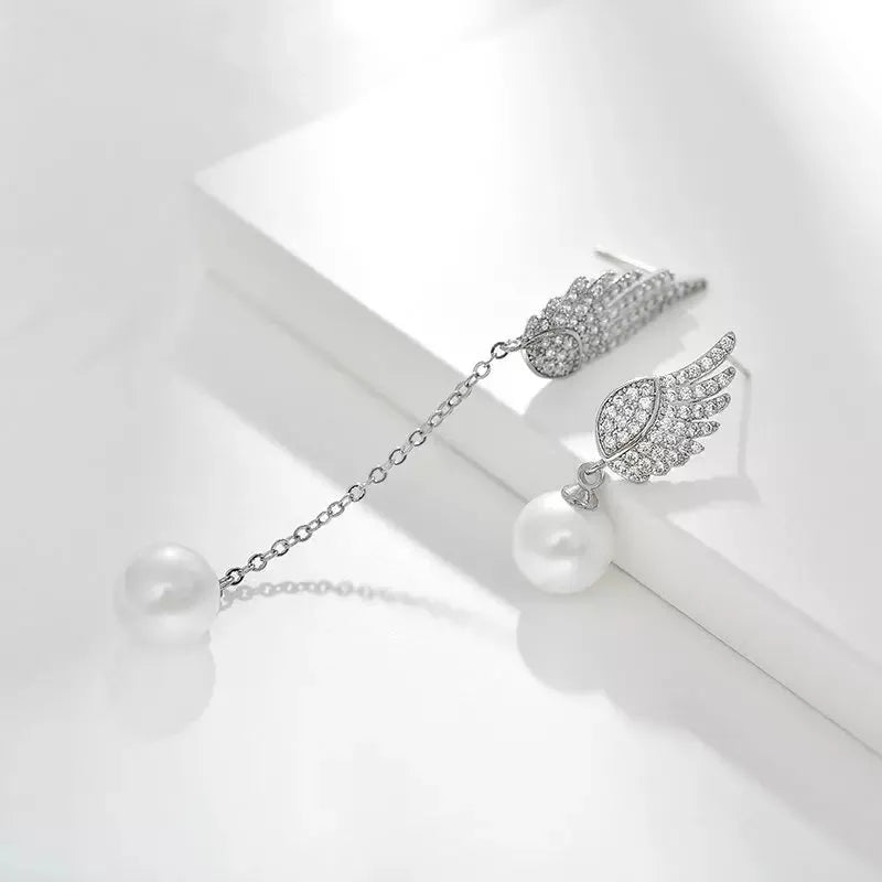 Silver angel wing earrings with diamond-cut treatment and gemstone inlay on platinum background