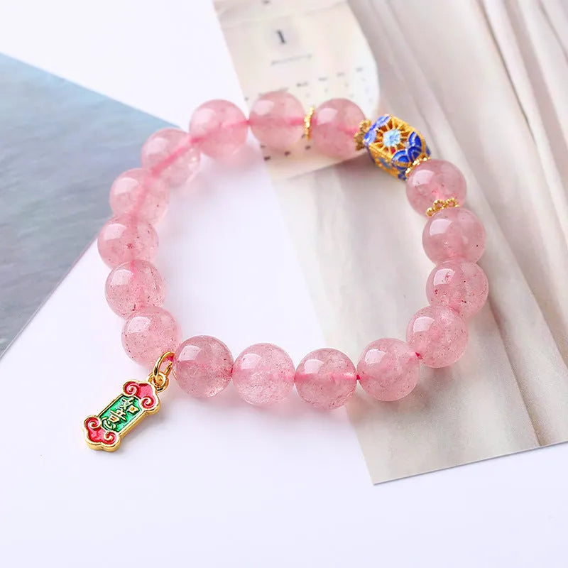 Pink strawberry quartz crystal bracelet with hand-woven construction and traditional Ruyi symbols
