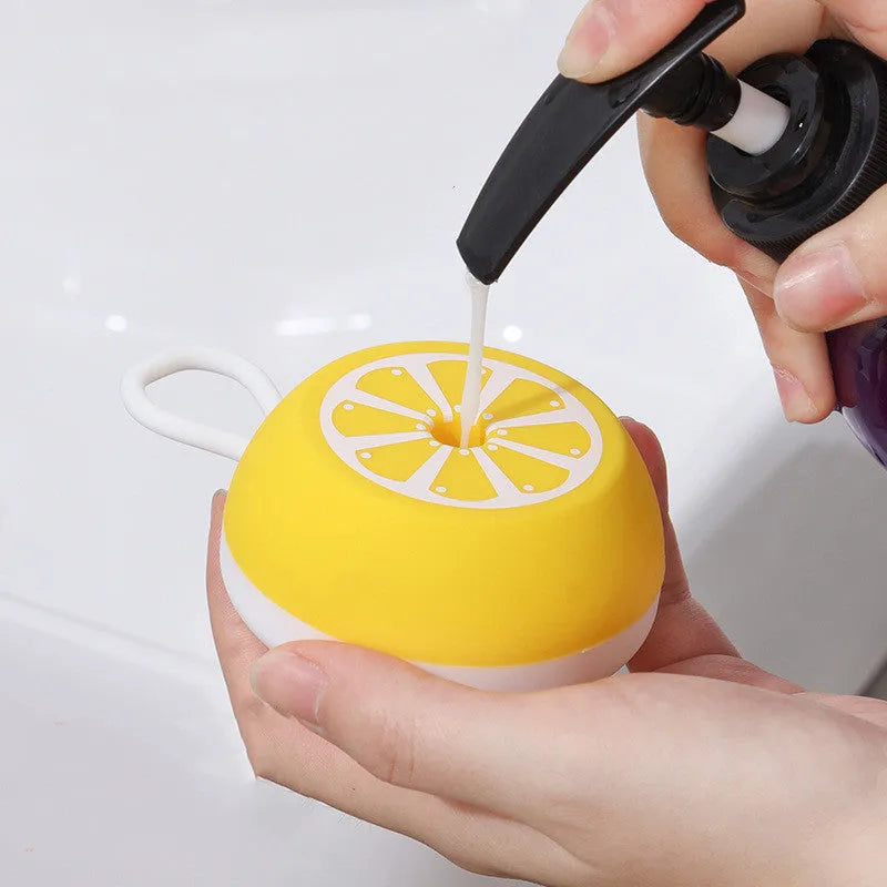 Yellow silicone pet bath brush and grooming comb tool held in a hand.