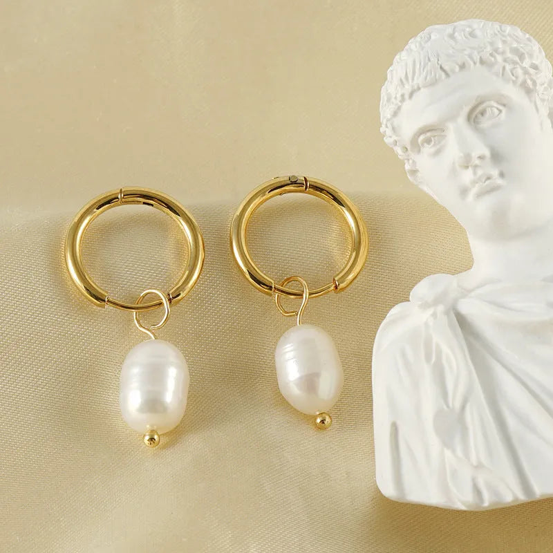 A pair of gold-coloured geometric earrings with a pearl detail, made from stainless steel.