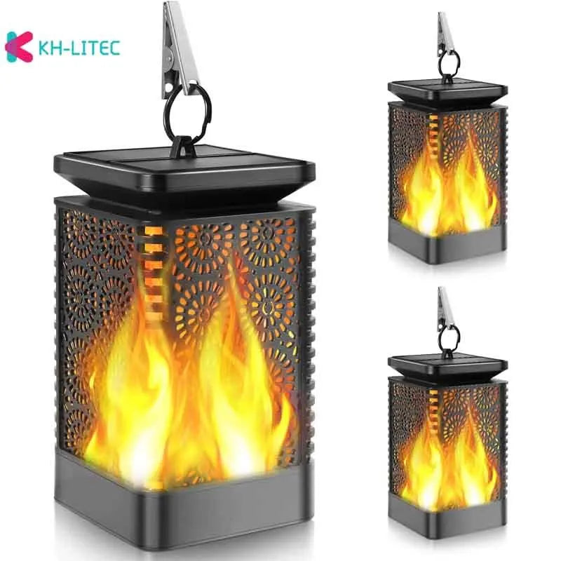 Set of four black solar-powered garden torch lights with flickering flame LED effect on a patio.