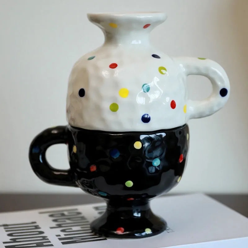 A hand-pinched ceramic mug with an irregular shape in a solid colour, shown on a table.