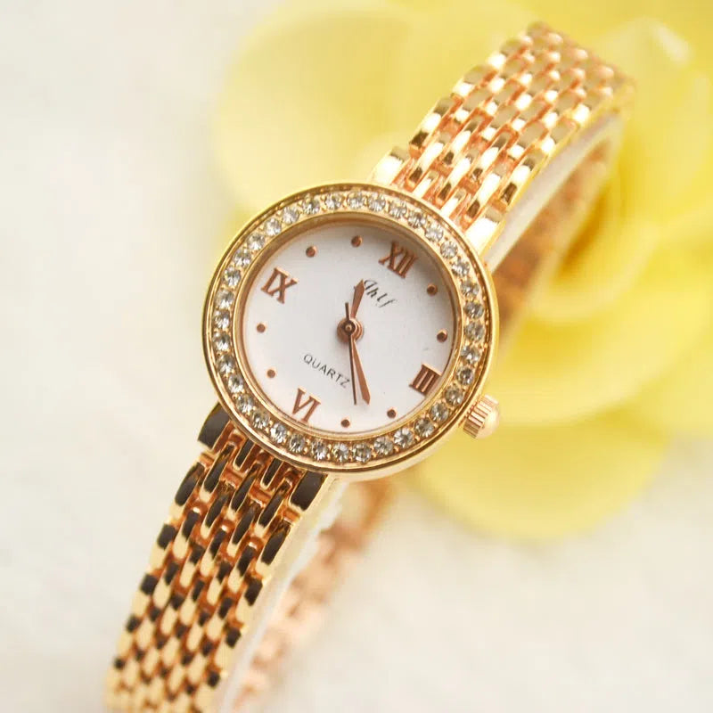 Gold alloy fashion quartz watch with rhinestone details, 20mm dial, and ordinary glass mirror on a neutral background