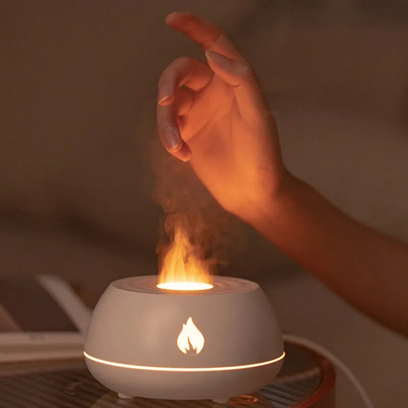 Black and white USB humidifier diffuser with glowing flame effect light on a wooden table.