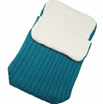 Envelope-style baby stroller sleeping bag in beige colour with thick filling, shown next to a pram.