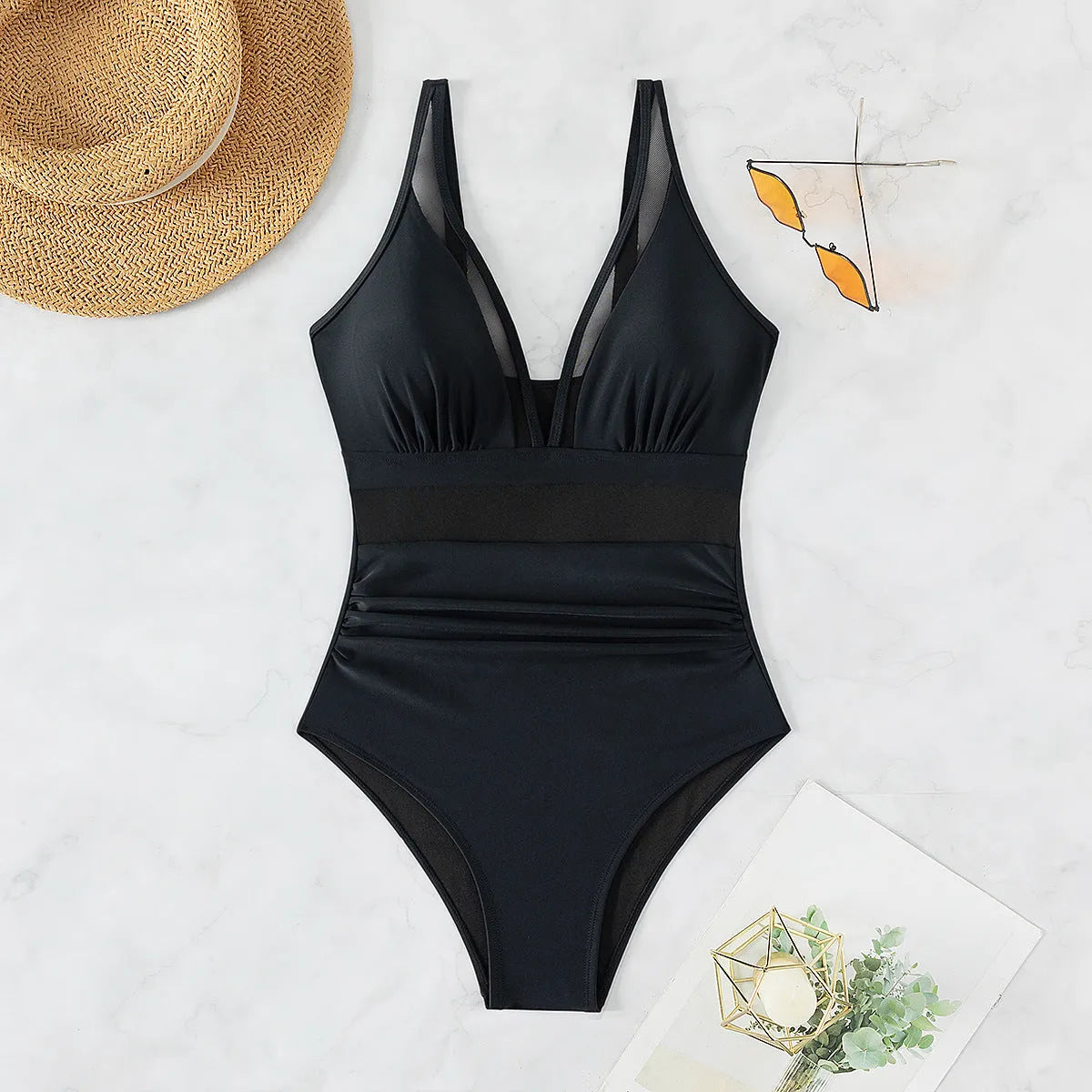 Black women's halter-neck one-piece swimsuit with mesh colour-block panels on mannequin.