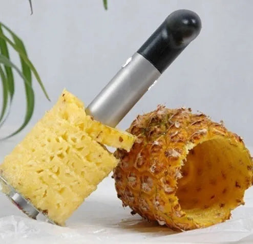 Stainless steel pineapple corer slicer with coloured ABS handle on a kitchen counter.
