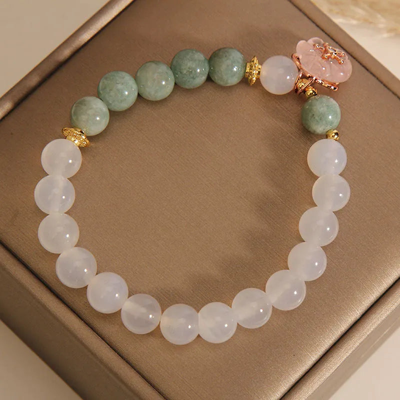 White agate floral bracelet with jade details and adjustable clasp on woman's wrist