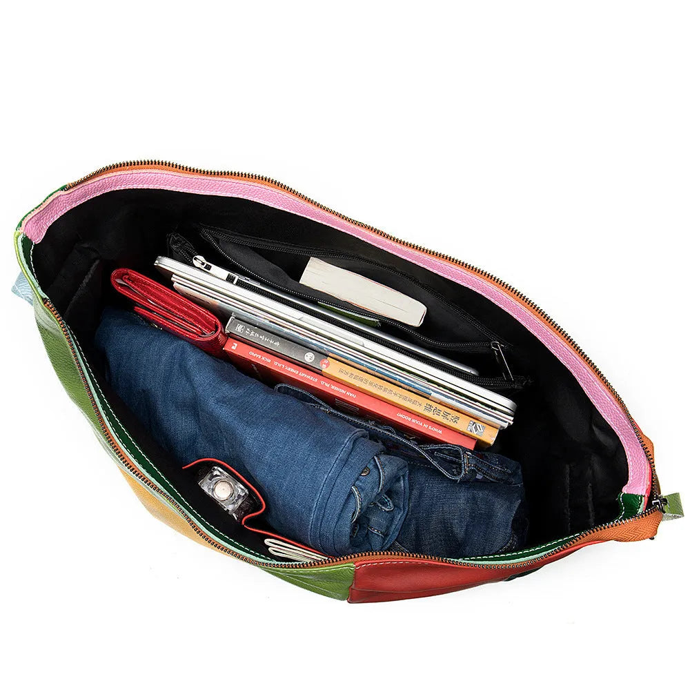 Brown cowhide leather travel bag shown as a crossbody style, with stitching details and enough space for a laptop and magazines.