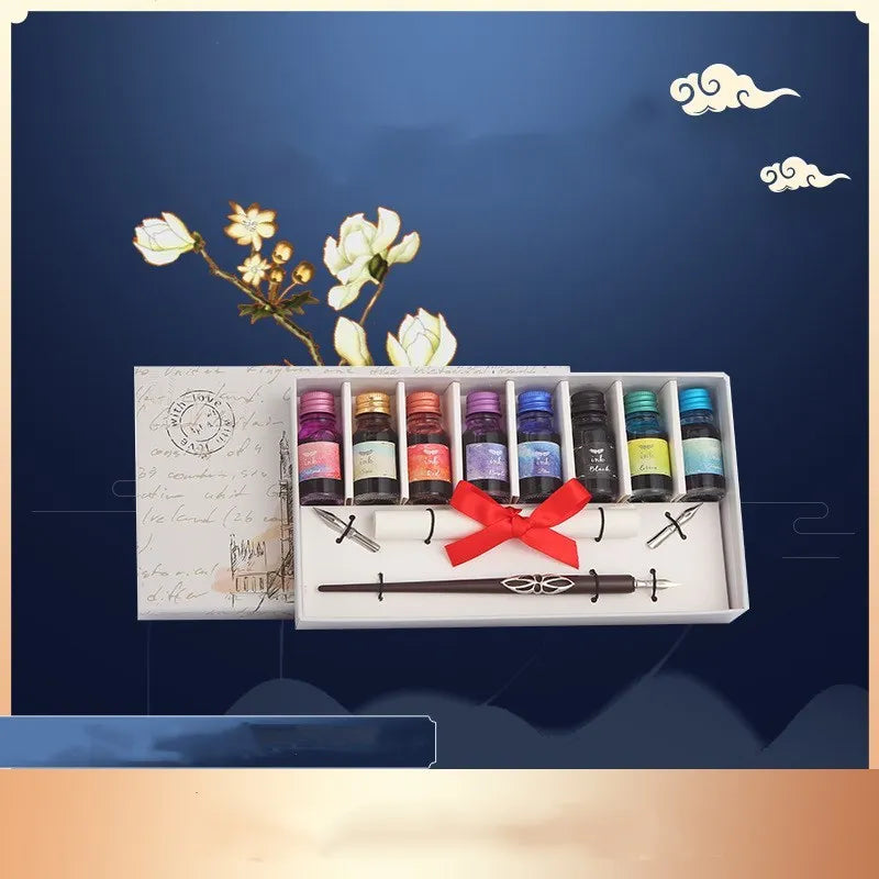 Wooden gift box open to show a wooden dip pen, standing pen holder, bottles of coloured ink, and replacement nibs.