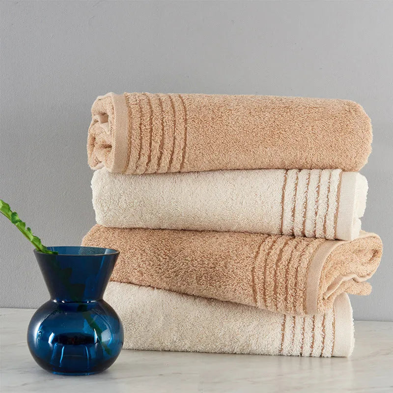 Set of three cotton towels in beige and brown colours, showing small, medium, and large sizes.