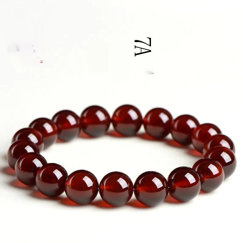 Close-up of a natural orange red garnet crystal bracelet in a unisex retro style with Ruyi design elements.