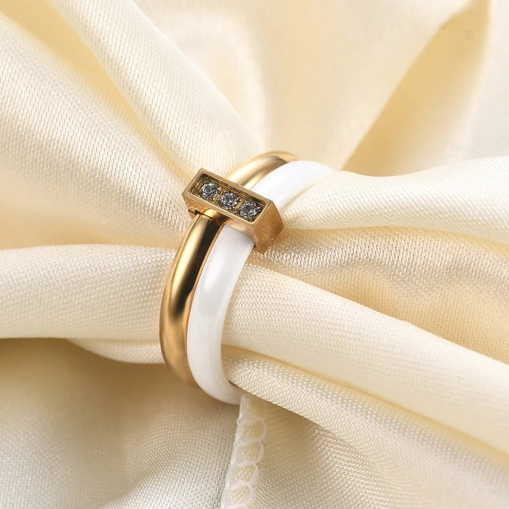 Close-up of a women's geometric ceramic ring with a 6mm wide band and glossy stitching detail, shown in a gold white electroplated finish.