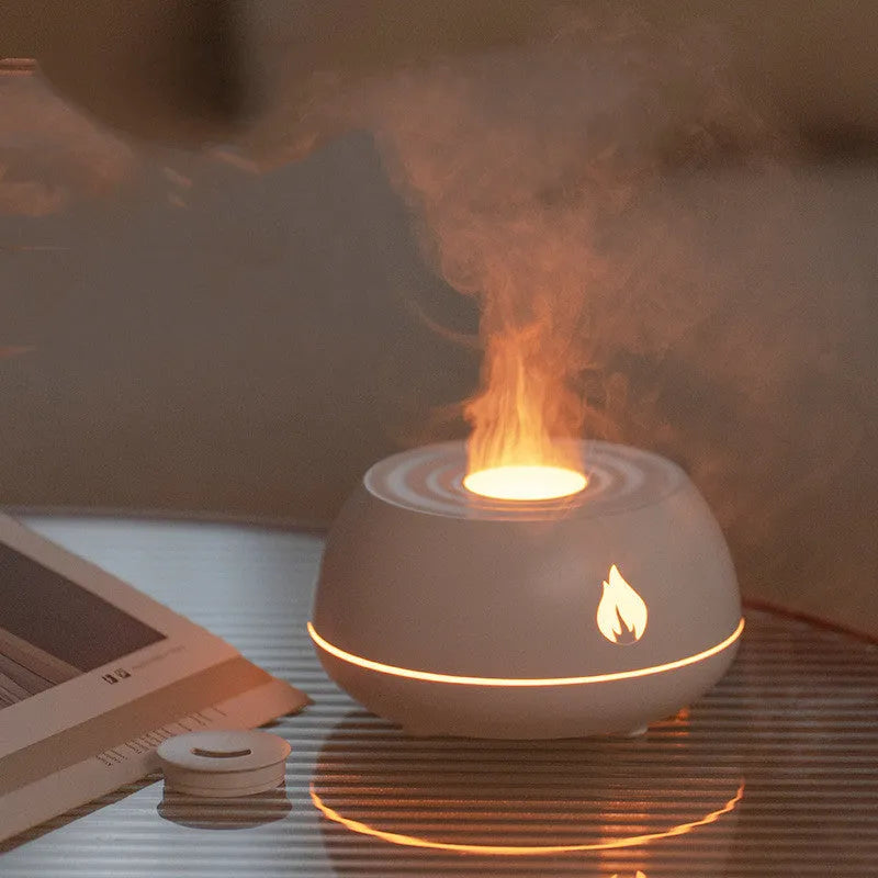 Black and white USB humidifier diffuser with glowing flame effect light on a wooden table.