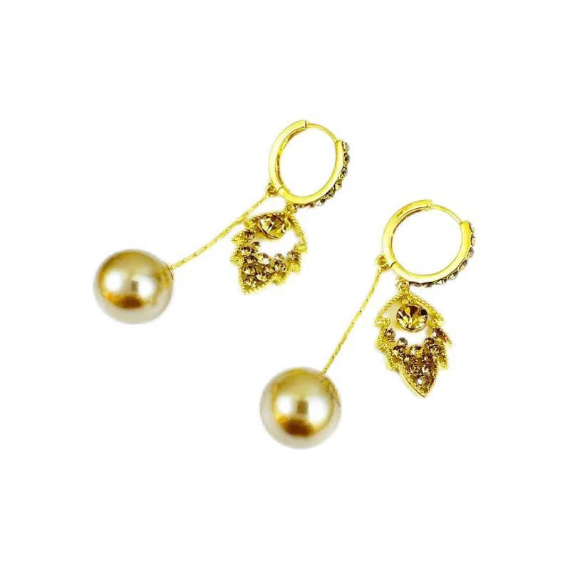 Coffee-coloured metal leaf earrings with full diamond-cut surface and pearl accents, old money style, side view on white background