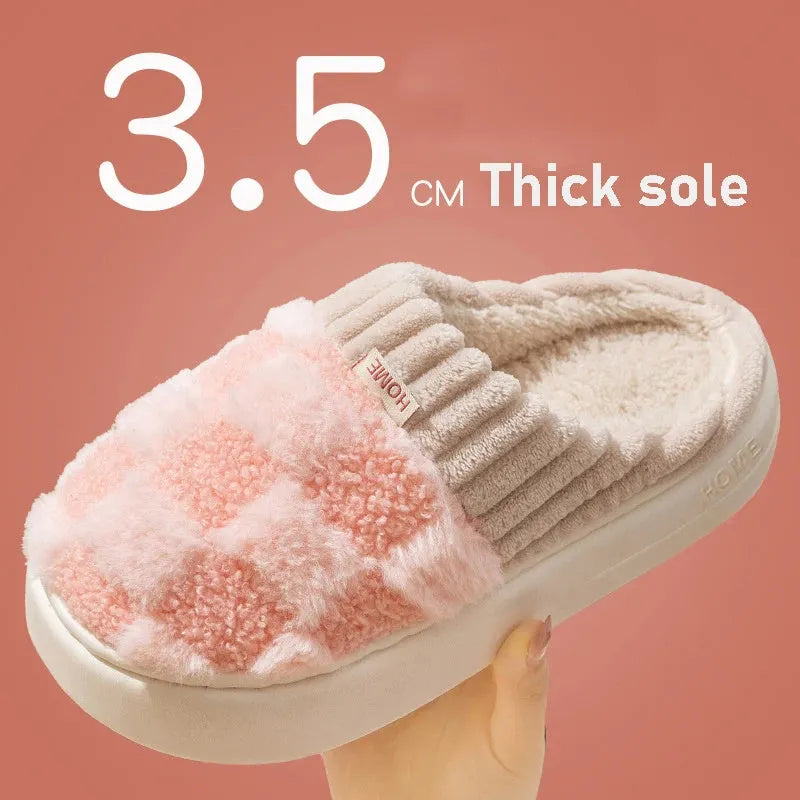 Plaid pattern women's plush indoor slippers in grey with a round toe and flat heel on a non-slip sole.