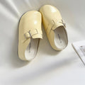 Flat buckle casual sneakers in yellow, creamy-white, silver, and black colours with round toe.
