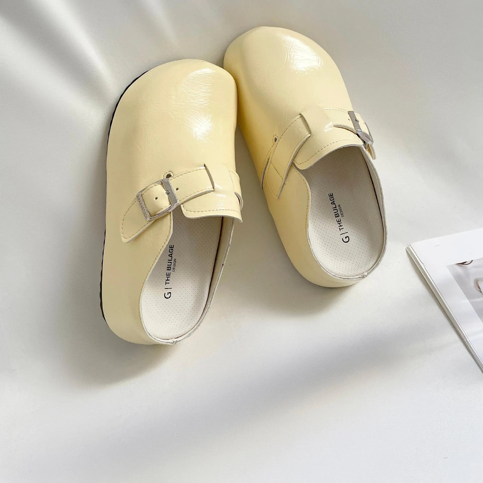 Flat buckle casual sneakers in yellow, creamy-white, silver, and black colours with round toe.
