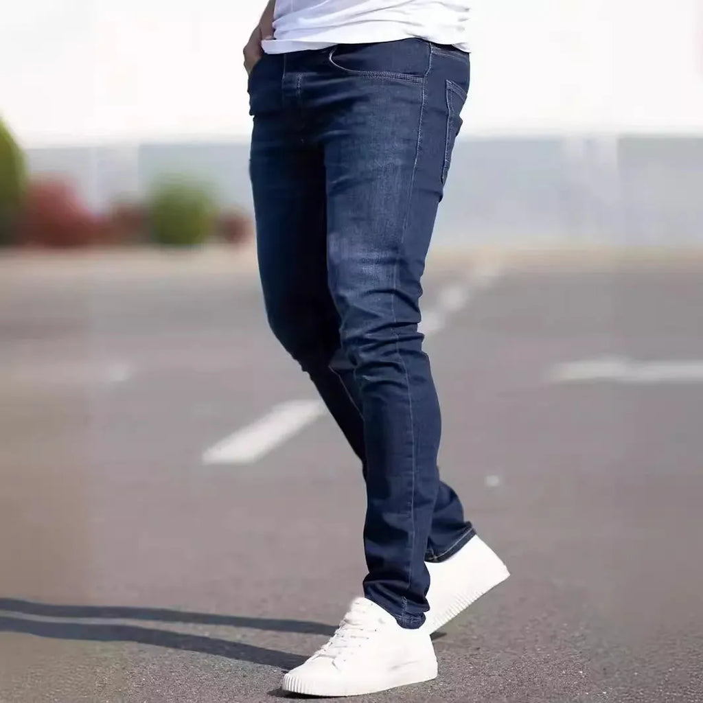 Man wearing dark blue slim fit skinny jeans with a mid-rise waist and zipper fly.