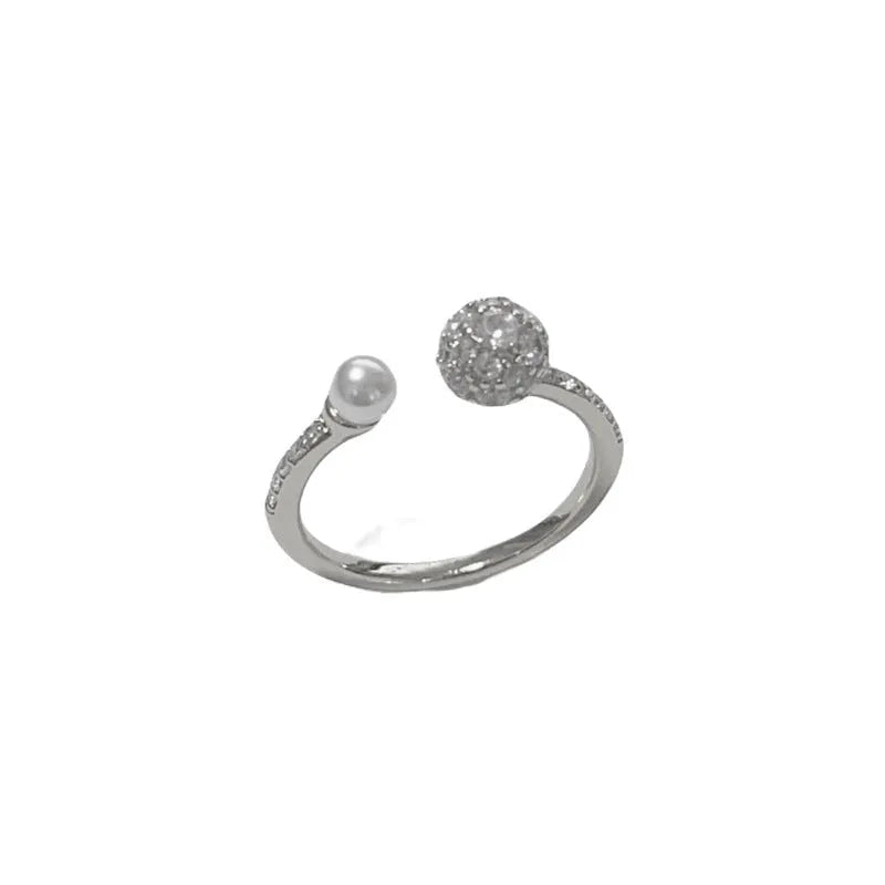 Gold or silver coloured open-end women's ring with round zircon stones and pearl detailing on a geometric band.