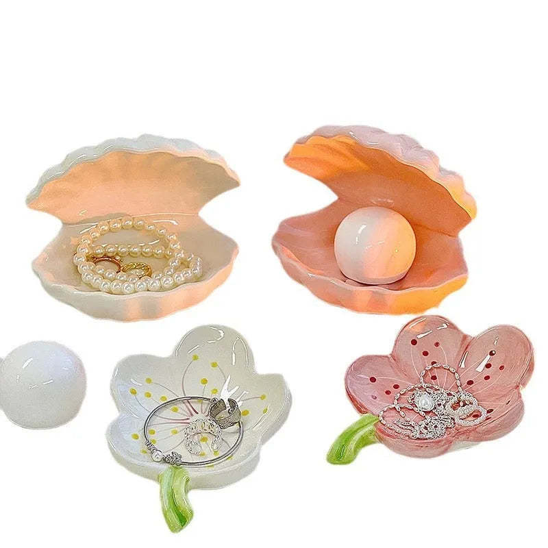 Yellow and white porcelain shell-shaped tray with integrated small LED night light on a wooden surface.