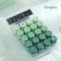 Gradient colour round mechanical keyboard calculator in muted blue, green, pink, or purple on a desk.