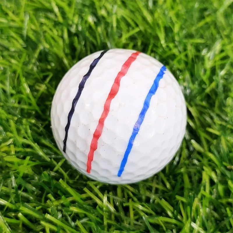 Golf ball alignment tool with four scriber pins and a drawing pen on a green.