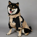 Khaki coloured polyester shell jacket for a dog on a white background.