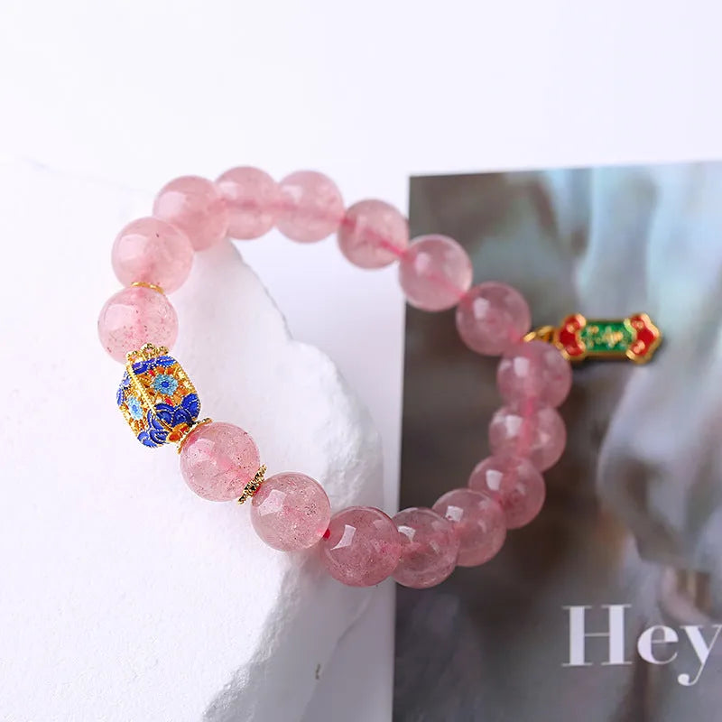 Pink strawberry quartz crystal bracelet with hand-woven construction and traditional Ruyi symbols