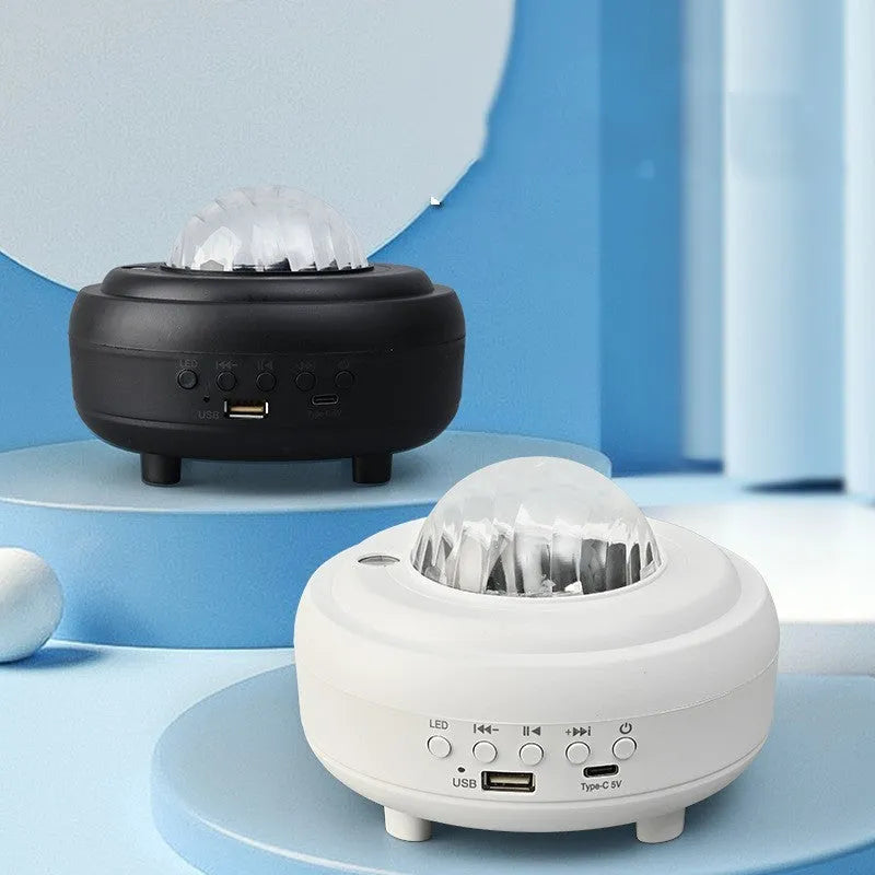 White Galaxy Star Projector Night Light on a table projecting blue starry sky onto a ceiling.