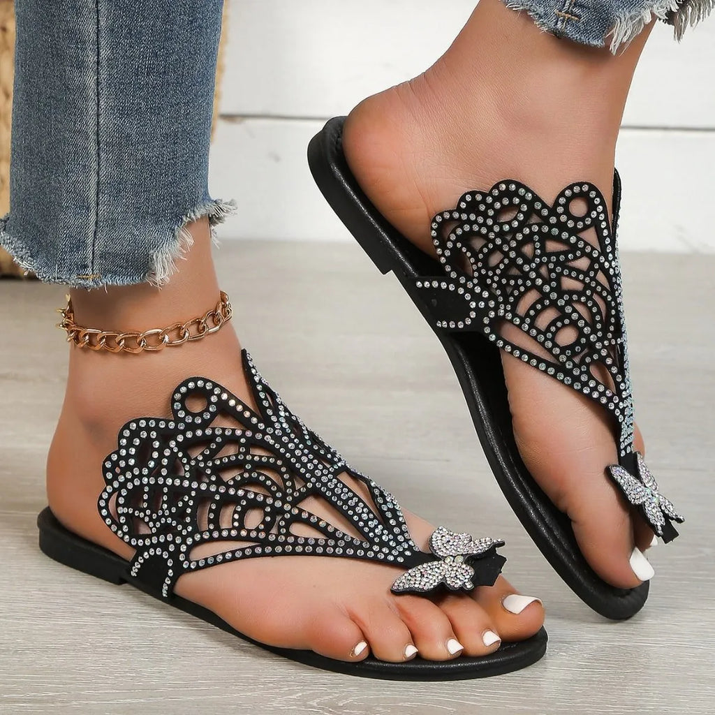 Women's black slip-on sandals with rhinestone decoration on a flip-toe, hollowed slipper design.