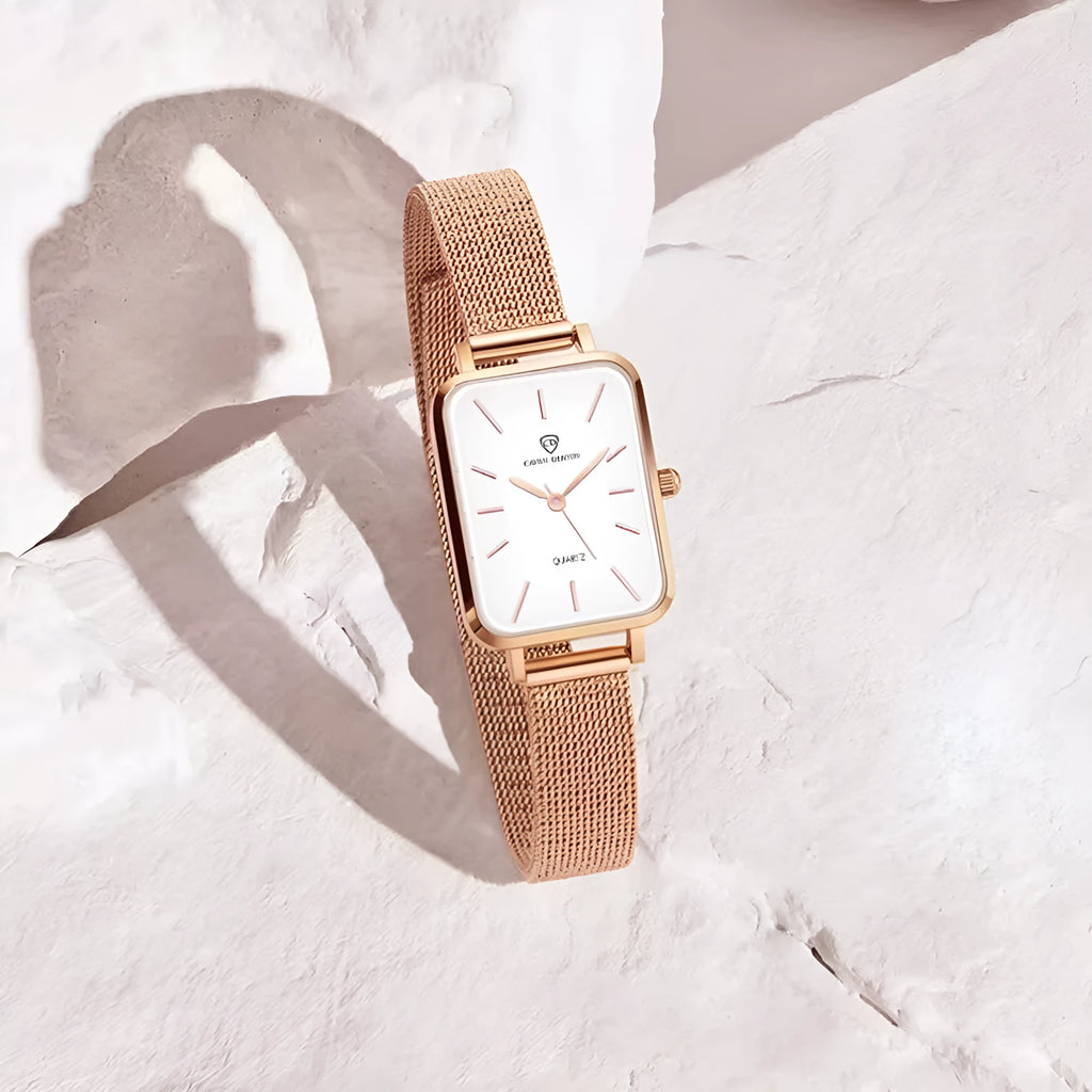 Women's rose gold waterproof quartz watch with woven steel strap on wrist.