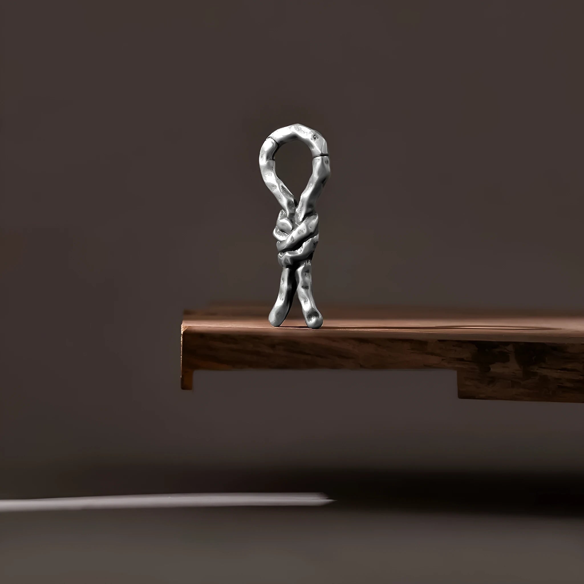 Close-up of a single 4mm copper piercing earring with a retro bending and connecting shape.