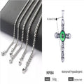 Stainless steel cross skull pendant with green eye detail in U-shaped geometric form on a chain